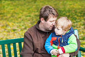 A person sitting beside a child